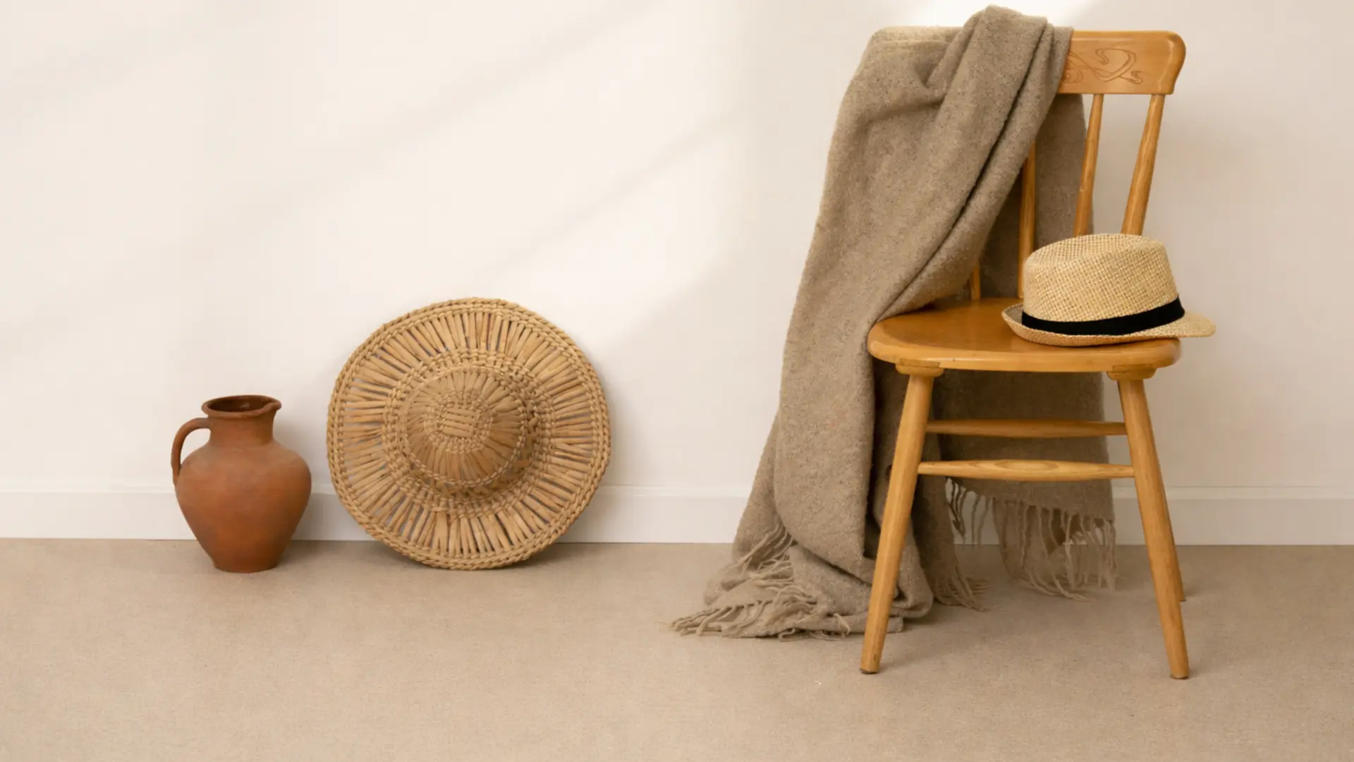 Mur blanc avec une chaise, un chapeau de paille et un pot en terre cuite sur un sol en linoléum